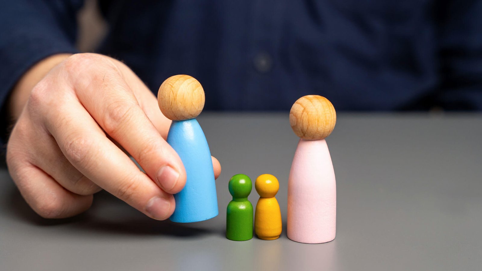 Persona acomodando figuras pequeñas de madera