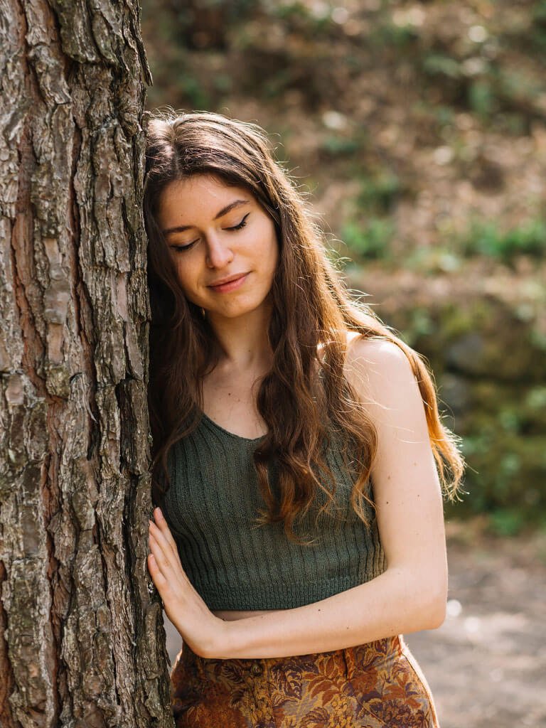 Mujer sentada sujetando su sombrero